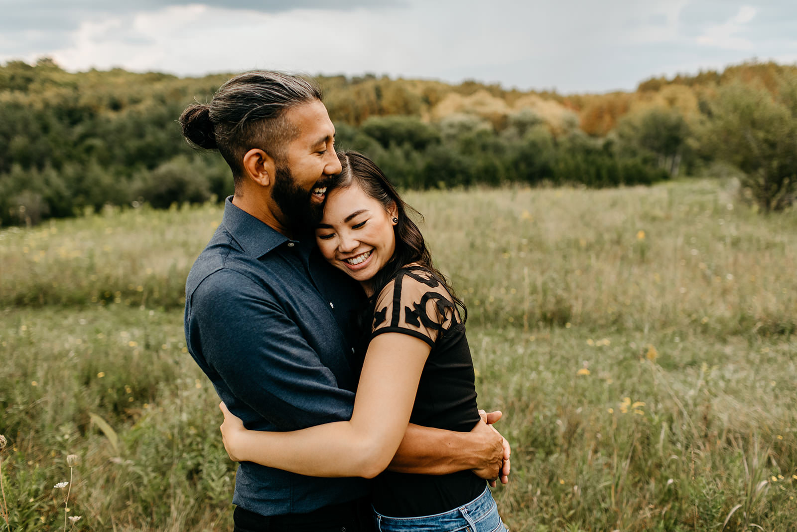 hugging in a field to celebrate being engaged