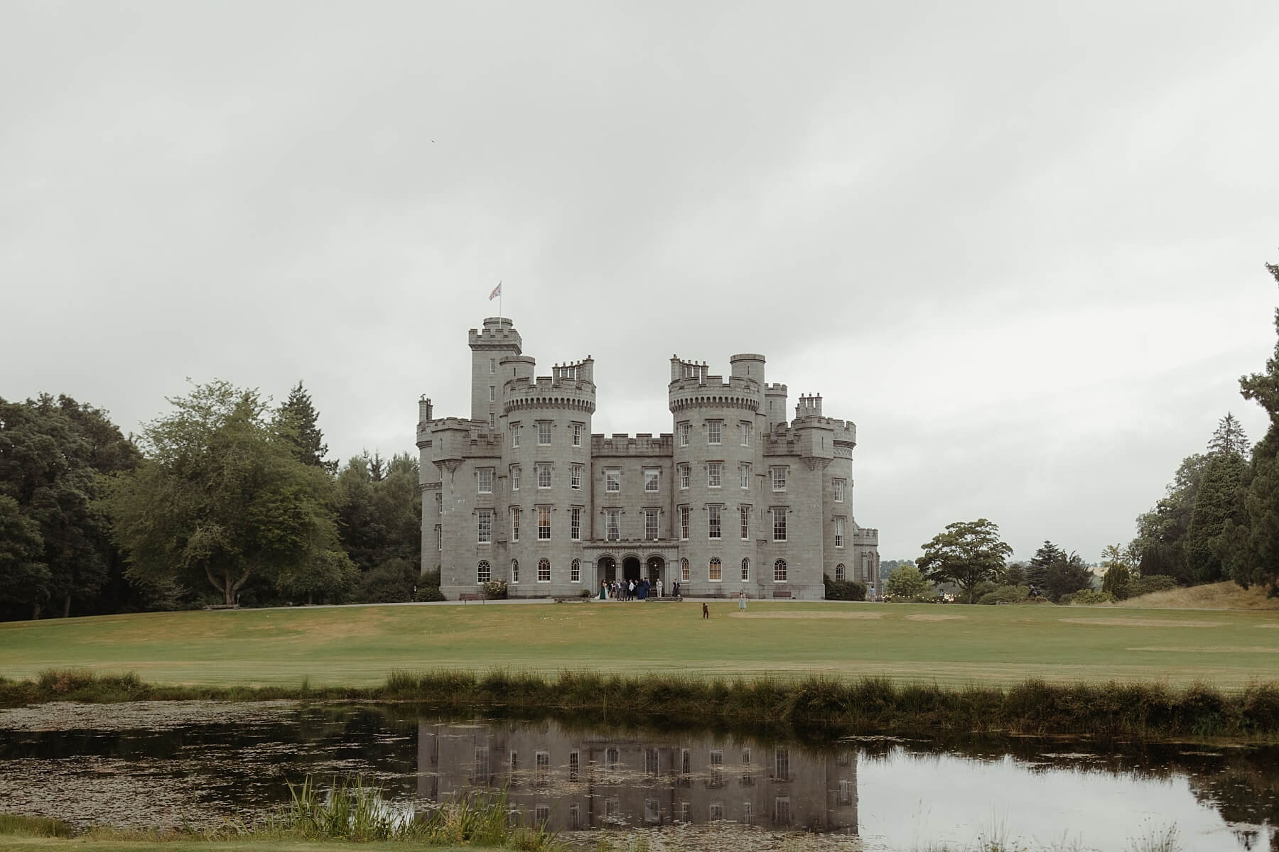 cluny castle wedding scotland exterior with pond lake loch in foreground